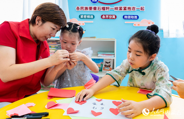 8月3日，内蒙古呼和浩特市玉泉区梁山街社区新时代文明实践站的志愿者在指导社区居民制作“爱在七夕”心愿卡。丁根厚摄