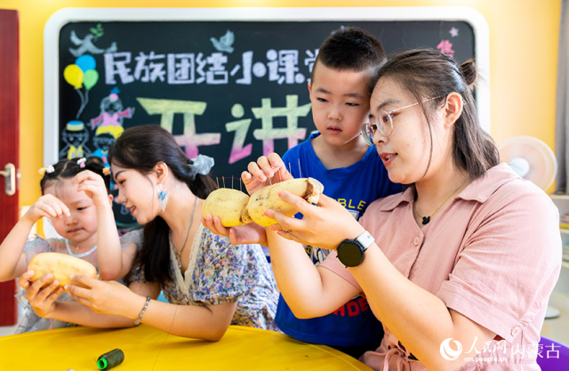 8月3日，内蒙古呼和浩特市玉泉区梁山街社区居民在“我们的节日·七夕”志愿服务活动现场体验“穿针乞巧”。丁根厚摄